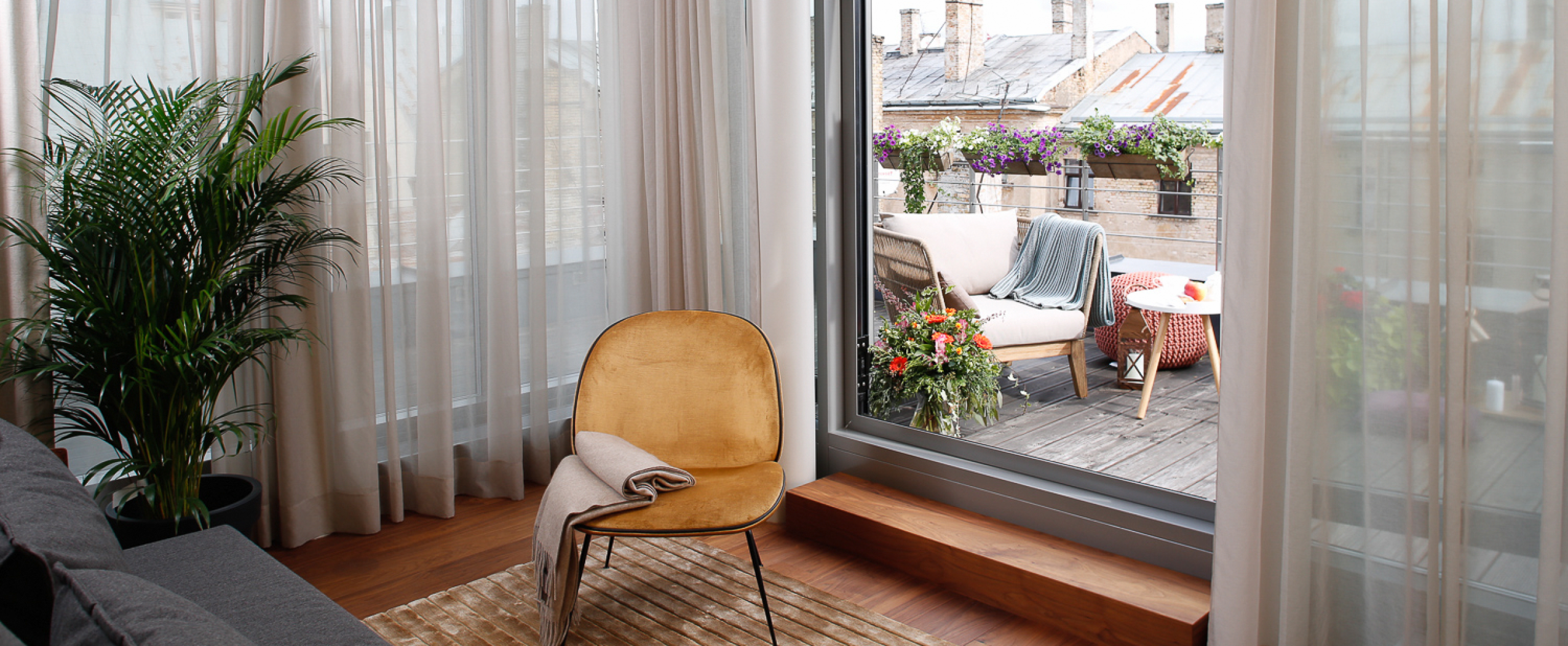 Уютно оформленная терраса здания CENTRUS с видом на крыши и панораму центра Риги.