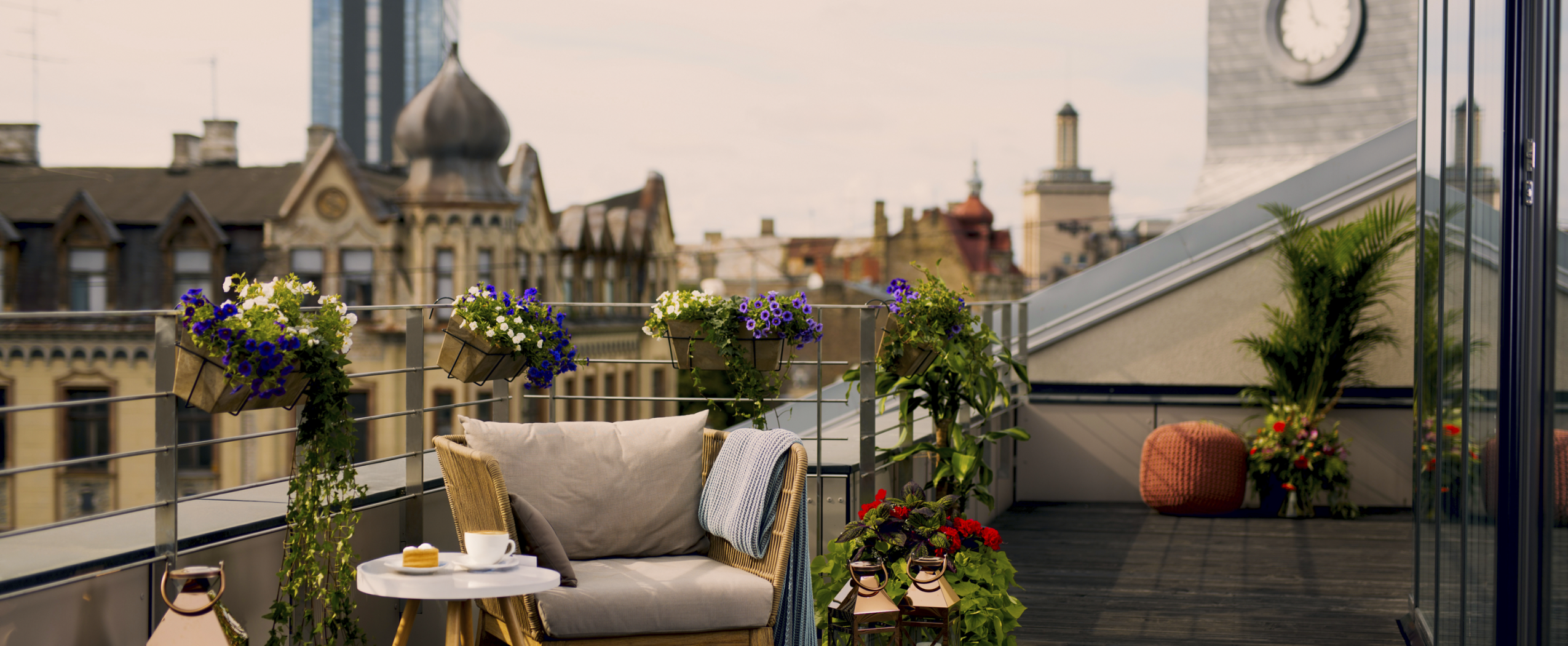 A cozy, beautifully designed terrace of the CENTRUS building with a panoramic view over the rooftops of Riga’s city center.
